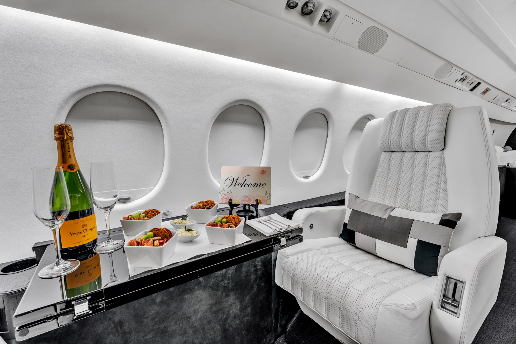 Falcon 900 window seat with a dining table set with champagne and refreshments